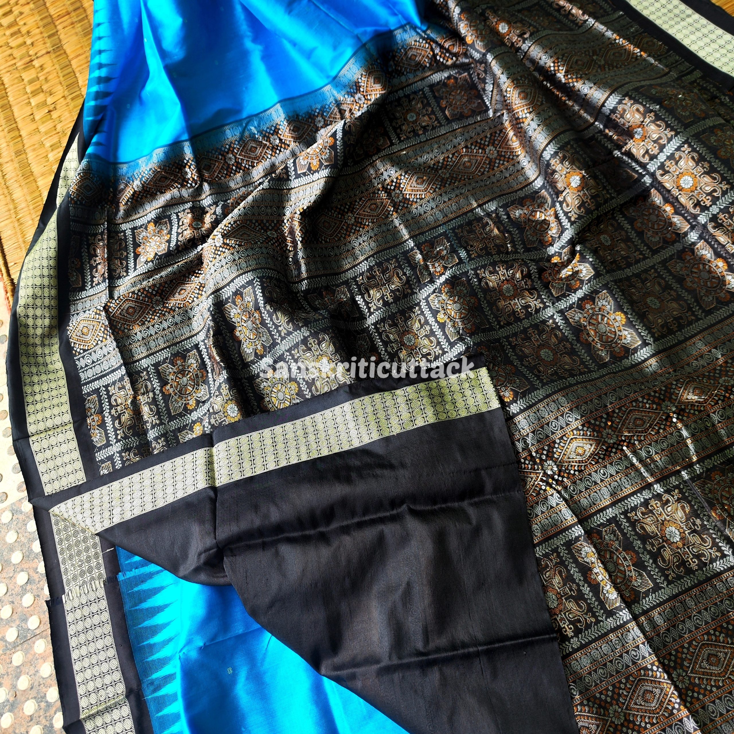 Photo_1731318192304 handloom Bomkai silk saree, traditional Odisha saree, authentic Bomkai silk, Bomkai pata saree, handloom silk saree, Odisha handloom saree, copper sulfate Bomkai saree, saree for special occasions, Bomkai silk saree with blouse, black border saree, elegant handloom saree, silk saree for festive wear, designer Bomkai saree, black pallu Bomkai saree, traditional handloom Bomkai, copper sulfate saree for events, handcrafted Bomkai saree, saree for women, buy Bomkai silk saree, online Bomkai saree shopping, Odisha silk saree, saree with kumbha border, black and copper saree, premium Bomkai saree, wedding Bomkai silk, ethnic wear for women, luxury Bomkai silk