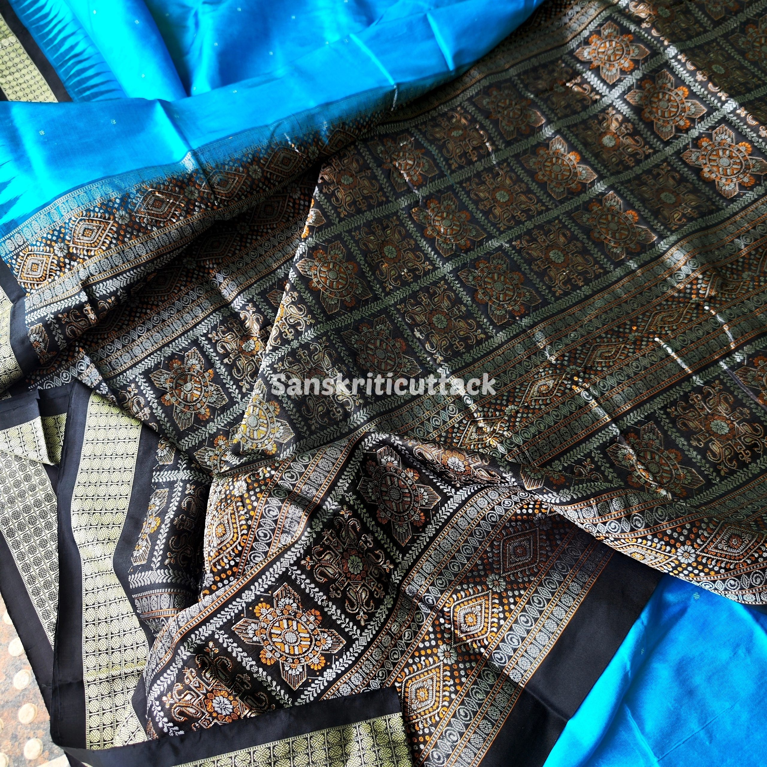 Photo_1731318224090 handloom Bomkai silk saree, traditional Odisha saree, authentic Bomkai silk, Bomkai pata saree, handloom silk saree, Odisha handloom saree, copper sulfate Bomkai saree, saree for special occasions, Bomkai silk saree with blouse, black border saree, elegant handloom saree, silk saree for festive wear, designer Bomkai saree, black pallu Bomkai saree, traditional handloom Bomkai, copper sulfate saree for events, handcrafted Bomkai saree, saree for women, buy Bomkai silk saree, online Bomkai saree shopping, Odisha silk saree, saree with kumbha border, black and copper saree, premium Bomkai saree, wedding Bomkai silk, ethnic wear for women, luxury Bomkai silk